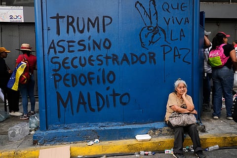 Graffiti that reads in Spanish, “Trump: murderer, kidnapper, pedophile, damned,” left, and “Long live peace,” covers a kiosk during a march to demand President Nicolas Maduro’s return, in Caracas, Venezuela, Tuesday, Jan. 6, 2026, three days after U.S. forces captured him and his wife.