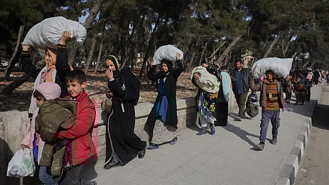 Residents carry their belongings as they are fleeing from Sheikh Maqsoud and Achrafieh neighborhoods.