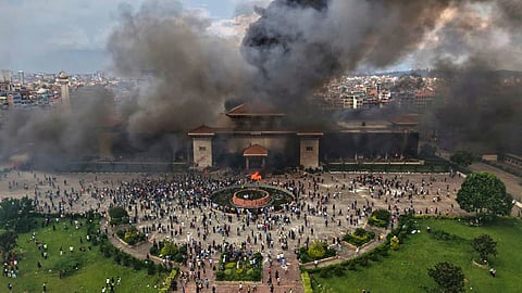 Protesters celebrate at the parliament building after it was set on fire during a protest against social media ban and corruption in Kathmandu, Nepal, on Sept. 9, 2025.