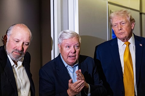 President Donald Trump, accompanied by Commerce Secretary Howard Lutnick, left, and Sen. Lindsey Graham, R-S.C., speaks with reporters while in flight on Air Force One, Sunday, Jan. 4, 2026, as returning to Joint Base Andrews, Md.