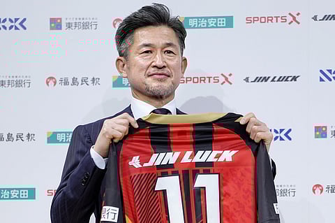 Japanese soccer player Kazuyoshi Miura poses with uniform of third-division J-League team Fukushima United. during a press conference in Tokyo, Japan, on Jan. 9, 2026.