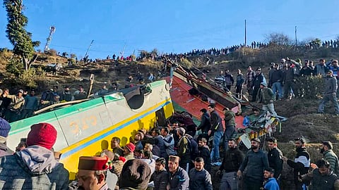  People gather around a private bus that rolled down into a deep gorge, in Sirmaur district, Himachal Pradesh, Friday, Jan. 9, 2026.