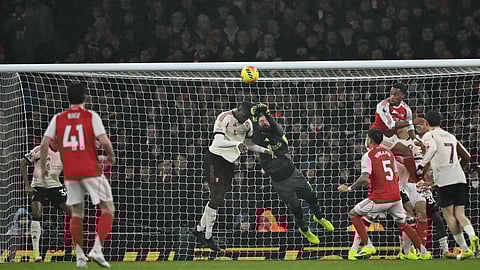 Liverpool's Alisson Becker (C) dives to punch the ball away from an Arsenal corner during the English Premier League football match between Arsenal and Liverpool on January 8, 2026.