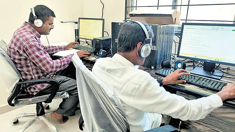 Two visually impaired persons use the computer at the sound library