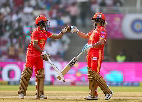 Gujarat Giants' captain Ashleigh Gardner and Anushka Sharma greet each other between the wickets during WPL T20 cricket match between Gujarat Giants and UP Warriorz.