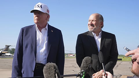 US President Donald Trump (left) listens as commerce secretary Howard Lutnick speaks with reporters before boarding Air Force One at Morristown Municipal Airport in Morristown, New Jersey, en route to Washington