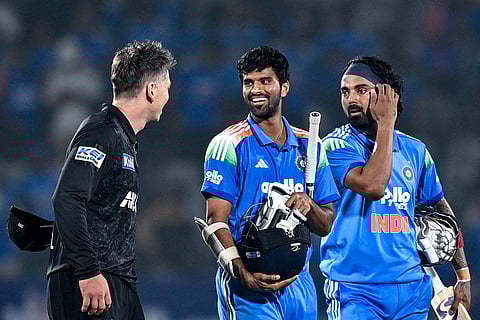 India's Washington Sundar (C) speaks with New Zealand's captain Michael Bracewell (L) as his teammate KL Rahul watches at the end of the first ODI cricket match between India and New Zealand in Vadodara on January 11, 2026.