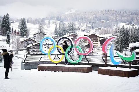 People take photos in front of the Milan Cortina Winter Olympics and Paralympics rings, in Cortina D'Ampezzo, Thursday, Nov. 20, 2025. 