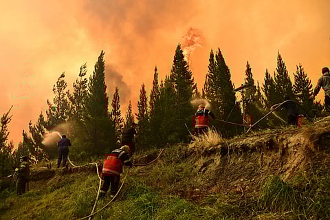 Firefighters battle flames as wildfires blaze in El Hoyo, Patagonia, Argentina, Thursday, Jan. 8, 2026. 