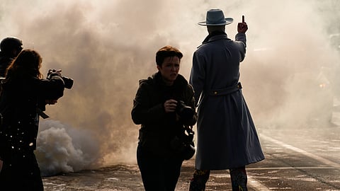 A man gestures as he walks toward a cloud of tear gas that was deployed by federal immigration officers Monday, Jan. 12, 2026, in Minneapolis.