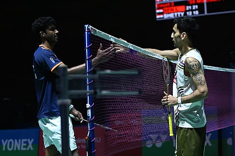 India's Lakshya Sen (R) shakes hands with compatriot Ayush Shetty after their men's singles Round of 32 match on Tuesday. Lakshya won 21-12, 21-15