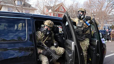Federal agents get ready to disperse tear gas into a crowd at a protest, Monday, Jan. 12, 2026 in Minneapolis.