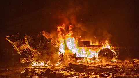 In this photo provided by the Ukrainian Emergency Service, emergency services personnel work to extinguish a fire following a Russian attack in Kharkiv, Ukraine, Tuesday, Jan. 13, 2026.