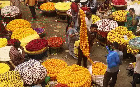 People buy flowers and other Puja materials at KR Market in Bengaluru