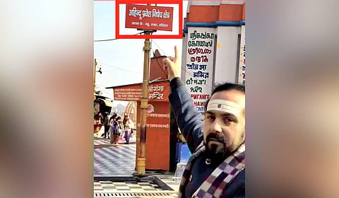 Temple priest Ujjwal Pandit showing the warning posters put up by the Shri Ganga Sabha in the 'Har Ki Pauri' area.