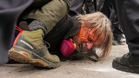 A man is pushed to the ground as federal immigration officers confront protesters outside Bishop Henry Whipple Federal Building, Thursday, Jan. 15, 2026, in Minneapolis.