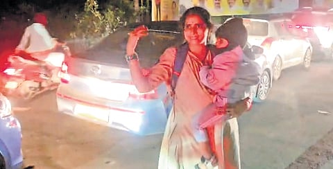 Police constable Jaya Shanti seen regulating traffic holding her child in one of her arms, at Samarlakota in East Godavari district.