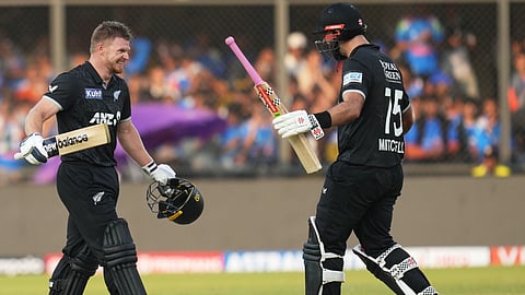 New Zealand's Glenn Phillips, left, walks towards batting partner Daryl Mitchell to celebrate his century during the third One Day International cricket match between India and New Zealand in Indore.