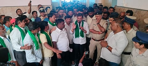 Magadi MLA H C Balakrishna speaking with the farmers who staged protest opposing the acquisition of their lands.