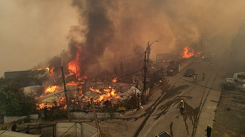 In this aerial view smoke and flames billow from burning houses during a wildfire in Concepcion, Chile, on January 18, 2026.
