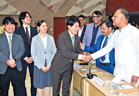 Health Minister Dinesh Gundu Rao greets delegates from Japan during the IMPACT-VIP Round Table Discussion in Mysuru on Monday.