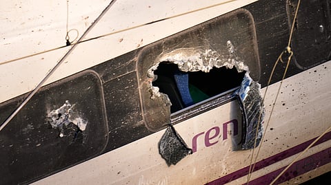 Broken windows of a crashed train are photographed at the site of a train collision in Adamuz, southern Spain, Monday, Jan. 19, 2026.