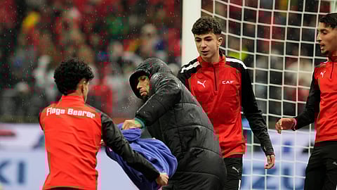 A ball boy attempts to grab a towel from Senegal's second-choice goalkeeper Yehvann Diouf as he holds it for Senegal's goalkeeper Edouard Mendy