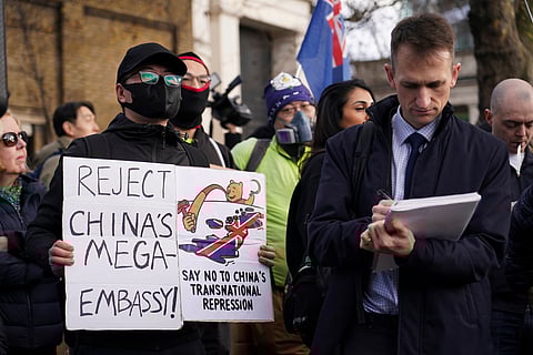 Demonstrators hold placards and flags as they attend a protest against the opening of the new Chinese embassy, in London, Saturday, Jan. 17, 2026.