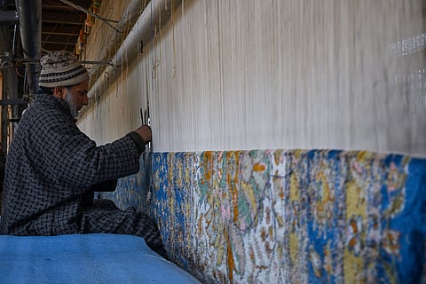 An artisan working on the carpet.