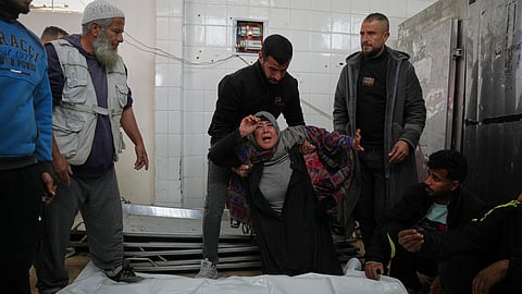 Najwa Al-Rajoudi mourns over the body of her nephew Moussa Al-Rajoudi before his funeral at Al-Aqsa Hospital in Deir al-Balah, central Gaza Strip, Wednesday, Jan. 21, 2026, after he was killed by Israeli fire.