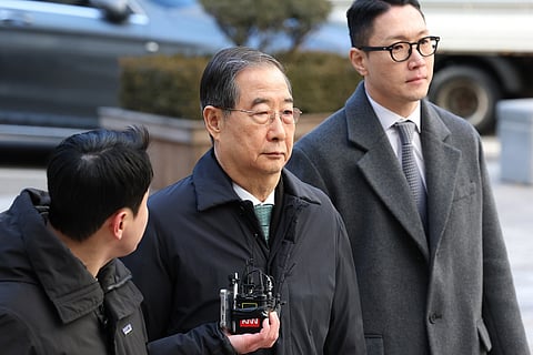 Former South Korean Prime Minister Han Duck-soo, center, arrives at the Seoul Central District Court for his first sentencing trial in the insurrection case, in Seoul Wednesday, Jan. 21, 2026.