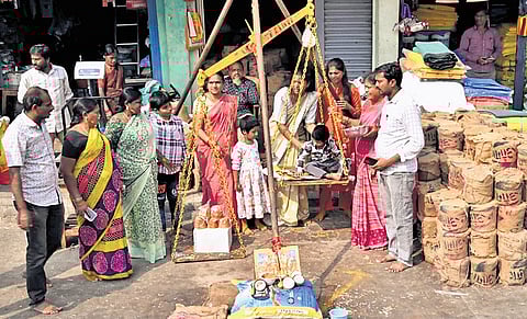 A helicopter waits for passengers; (left) devotees weigh jaggery to offer at the Sammakka-Saralamma Jatara on Thursday.