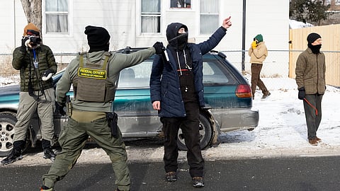 A federal immigration agent uses a chemical agent on an observer after detaining a man and his child on Thursday, Jan. 22, 2026, in Minneapolis.