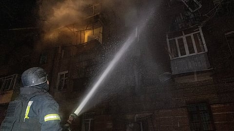 Emergency services personnel work to extinguish a fire following a Russian attack in Kharkiv, Ukraine, Saturday, Jan. 24, 2026. 