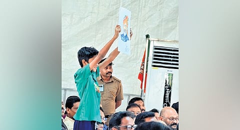 Siddharth holding a portrait of PM Narendra Modi that he drew, at the  at the BJP rally