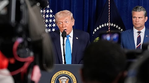 US President Donald Trump speaks at his Mar-a-Lago club on Saturday, Jan. 3, 2026, in Palm Beach, Fla., as Defense Secretary Pete Hegseth listens.