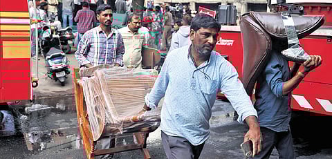 Store staff shift furniture items from the affected shop in Nampally, 
Hyderabad, on Saturday.