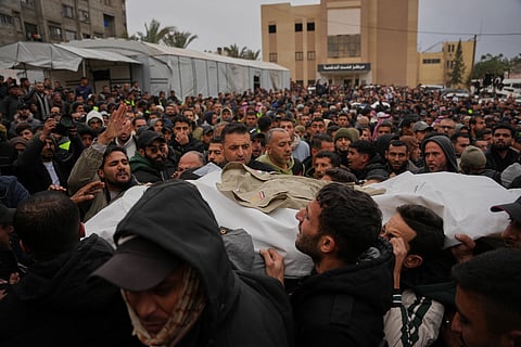 Mourners carry the body of Mohamed Qeshta, one of the three Palestinian journalists who were killed in an Israeli strike on an Egyptian committee's vehicle, during his funeral in Khan Younis, southern Gaza Strip, Thursday, Jan. 22, 2026.