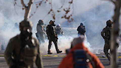 Federal immigration officers deploy tear gas at protesters after a shooting Saturday, Jan. 24, 2026, in Minneapolis.