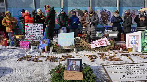 People gather near the scene where Alex Pretti was fatally shot by a U.S. Border Patrol officer yesterday, in Minneapolis, Sunday, Jan. 25, 2026. 