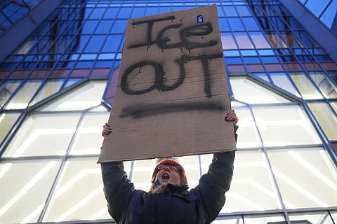 A demonstrator holds a sign reading "ICE OUT" during a protest outside the office of Sen. Amy Klobuchar, D-Minn., on Monday, Jan. 26, 2026, in Minneapolis. 