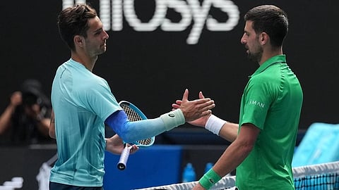 Lorenzo Musetti, left, of Italy shakes hands with Novak Djokovic of Serbia after retiring from their quarterfinal match at the Australian Open tennis championship in Melbourne, Australia, Wednesday, Jan. 28, 2026.