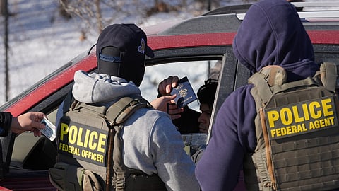 Federal agents make a traffic stop on a U.S. citizen as they provide their identification including a passport and drivers license, Tuesday, Jan. 27, 2026, in Minneapolis.