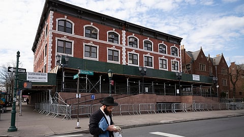 A man passes the Chabad-Lubavitch World Headquarters in the Crown Heights neighborhood of Brooklyn, April 7, 2020, in New York.