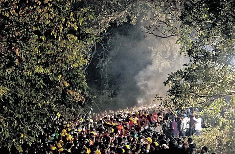 Amid a sea of devotees, Adivasi priests carry Goddess Sammakka deity from Chilakalagutta hillock to the altar at Medaram village in Mulugu district on Thursday.
