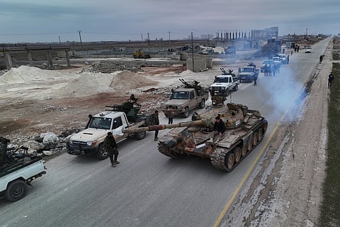 A convoy of Syrian government forces drives on a road leading to the town of Deir Hafer near Aleppo in Syria.