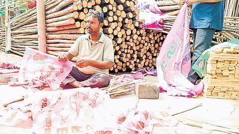 A trader fixes flags on bamboo sticks in Karimnagar on Wednesday