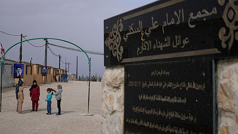 Syrian Shiite girls gather at the Imam Ali Housing Compound, where hundreds of mostly Lebanese and Syrian Shiite Muslims displaced from Syria reside, in Hermel, northeast Lebanon, Friday, Jan. 30, 2026. The Arabic words right, read:"The Imam Ali Housing Compound, families of the honorable martyrs."