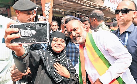 A woman takes a selfie with Union Minister of State for Home Affairs Bandi Sanjay Kumar during a municipal poll campaign rally in Huzurabad on Thursday