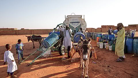 FILE - People fill water containers at a free distribution point due to water outages in Khartoum, Sudan, on Jan. 30, 2026.